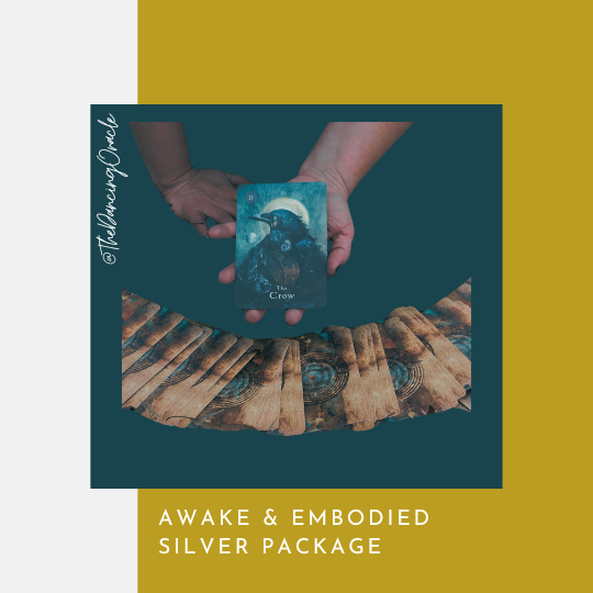 hand holding oracle card with a crow pictured over a spread of face-down oracle cards